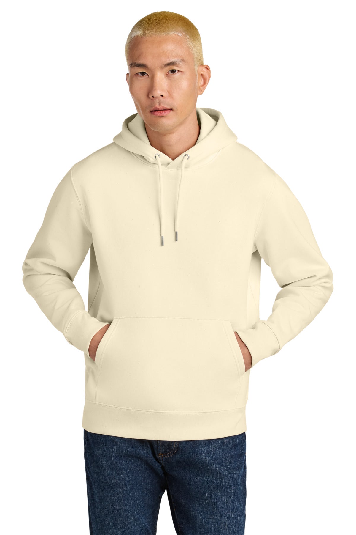 Man wearing a beige hoodie and blue jeans on a white background