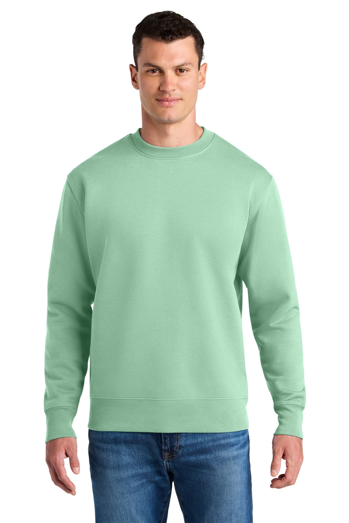 Man wearing a light green sweatshirt and blue jeans on a white background
