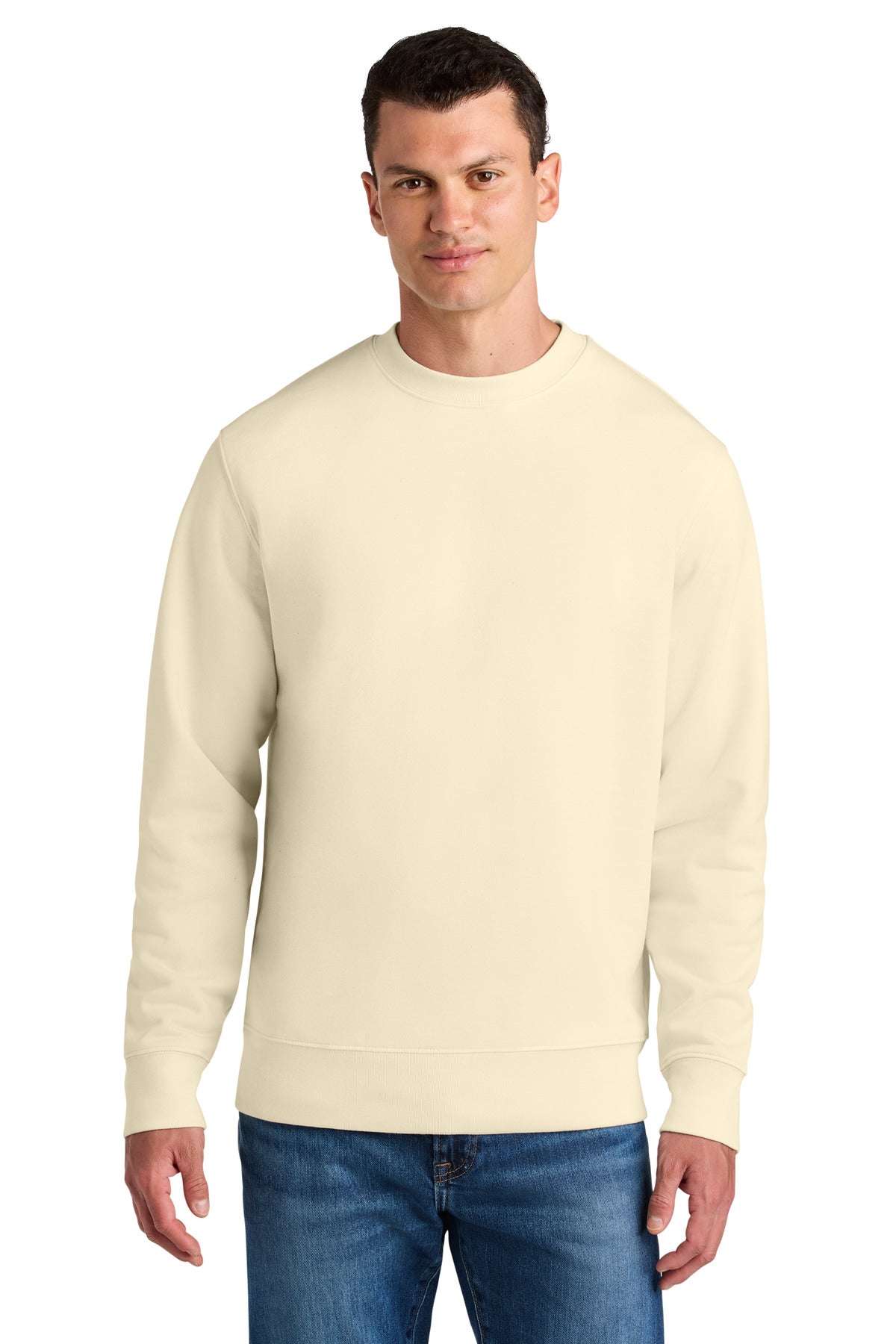 Man wearing a cream-colored sweatshirt and blue jeans on a white background