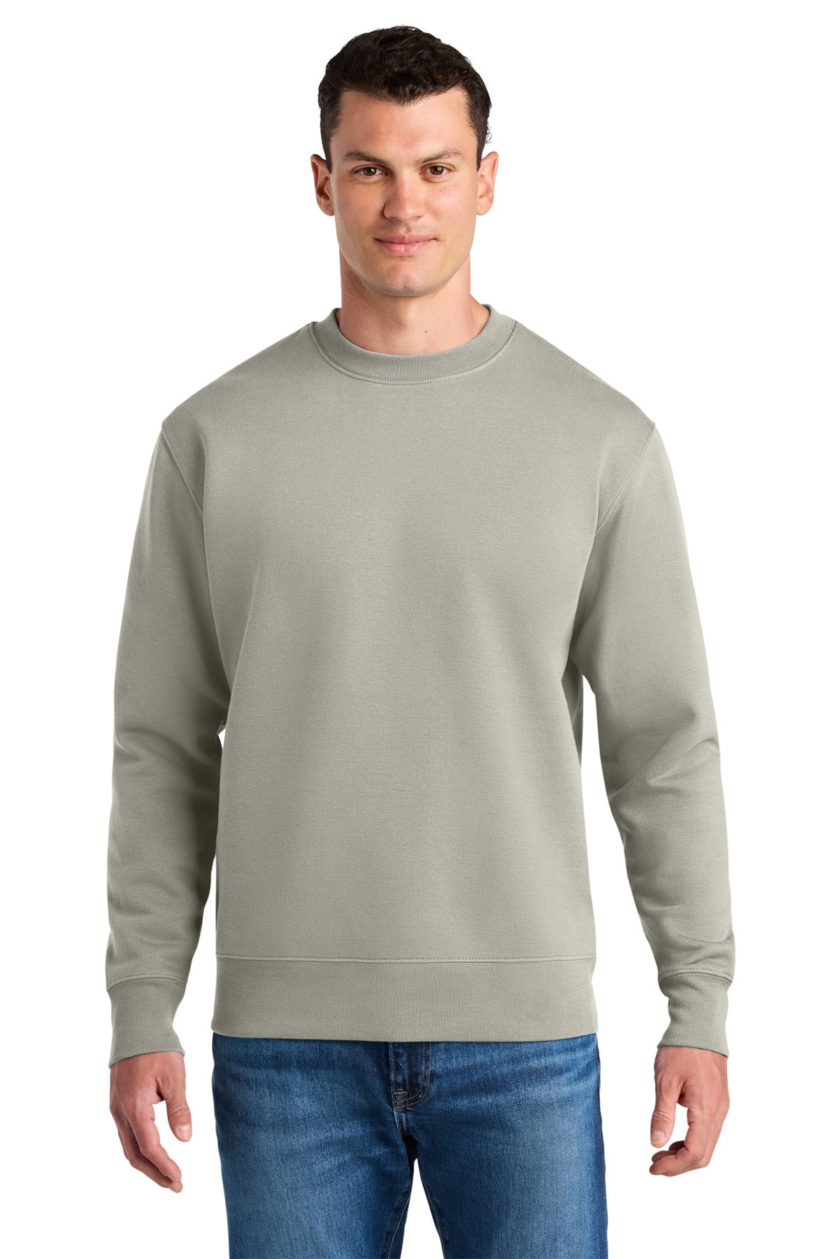 Man wearing a light gray sweatshirt and blue jeans on a white background