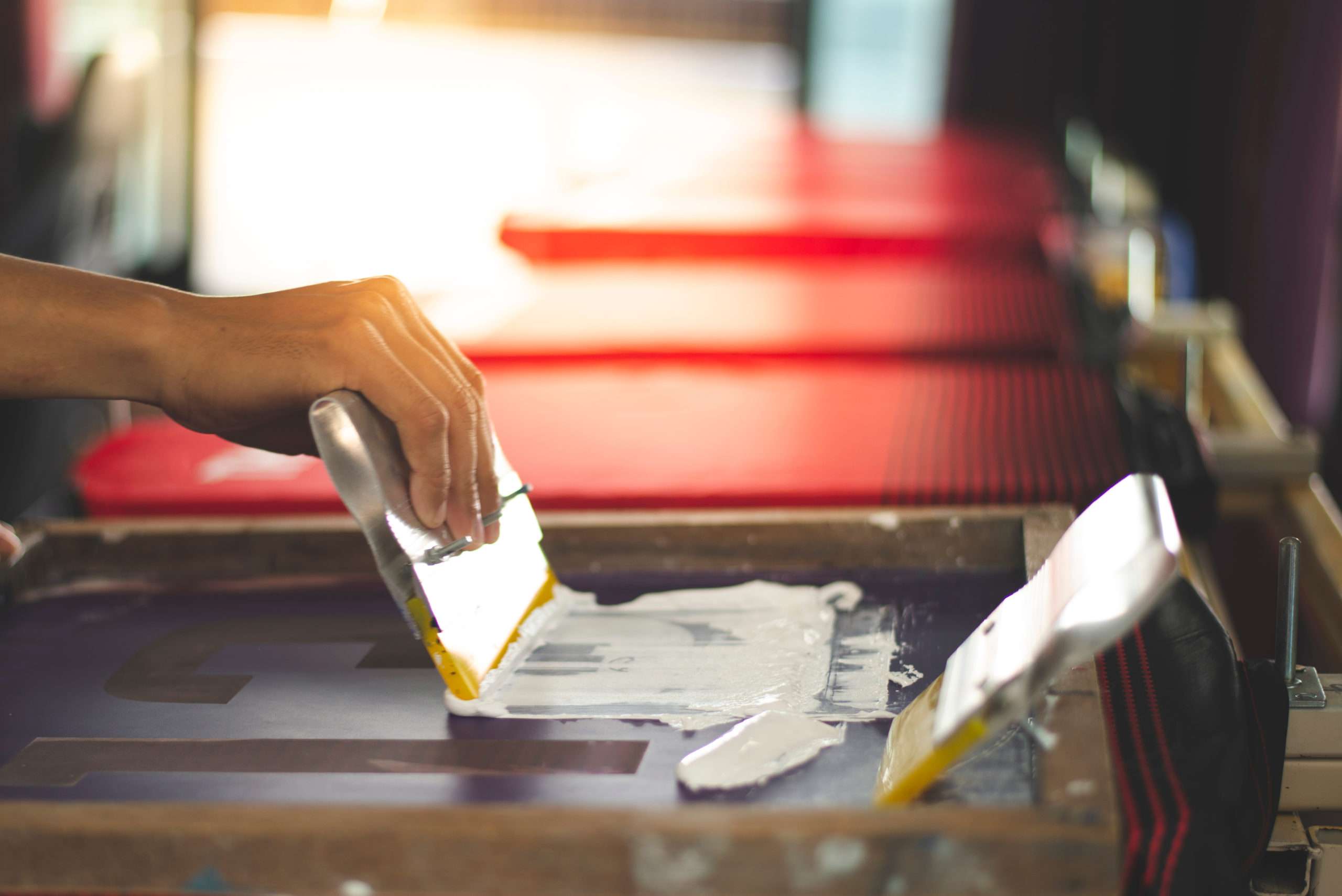 Person applying white paint to a surface with a brush