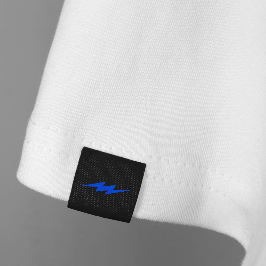 Close-up of a white garment with a black label featuring a blue lightning bolt on a gray background